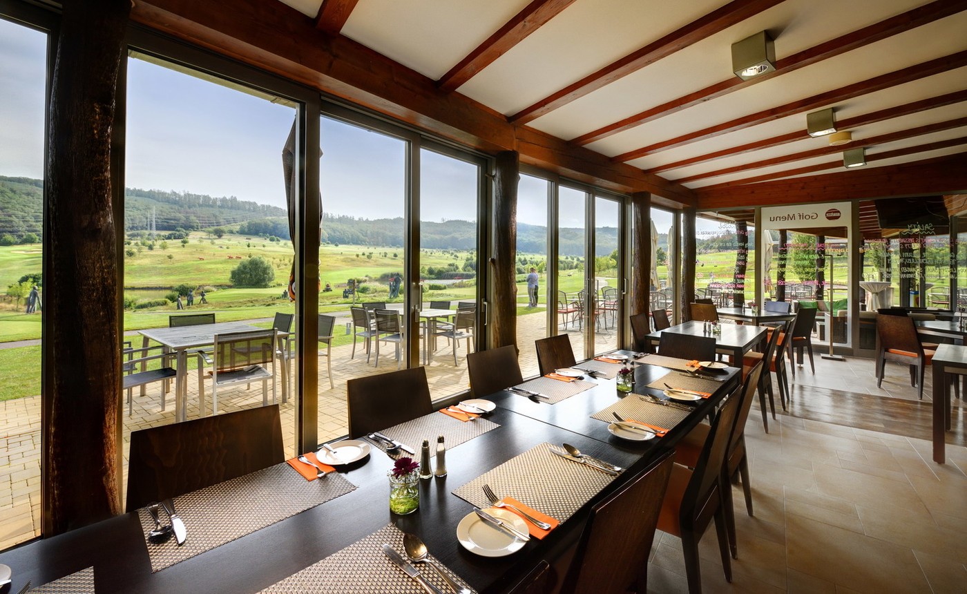 Restaurace s prostřenými stoly a výhledem na hřiště